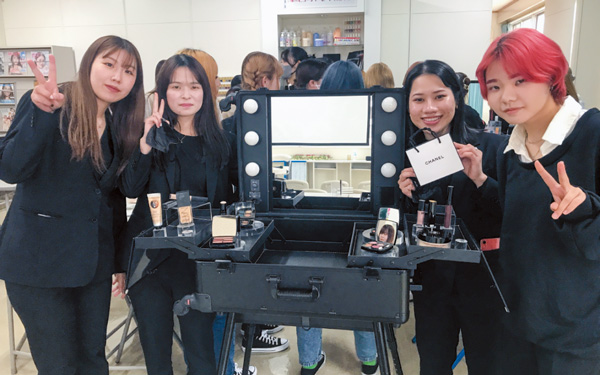 化粧台を囲んでピースをしている美容学生たち